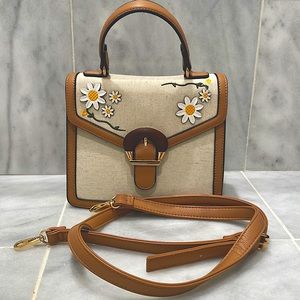 Daisy purse with attachable leather straps. Snap enclosure. Pockets inside